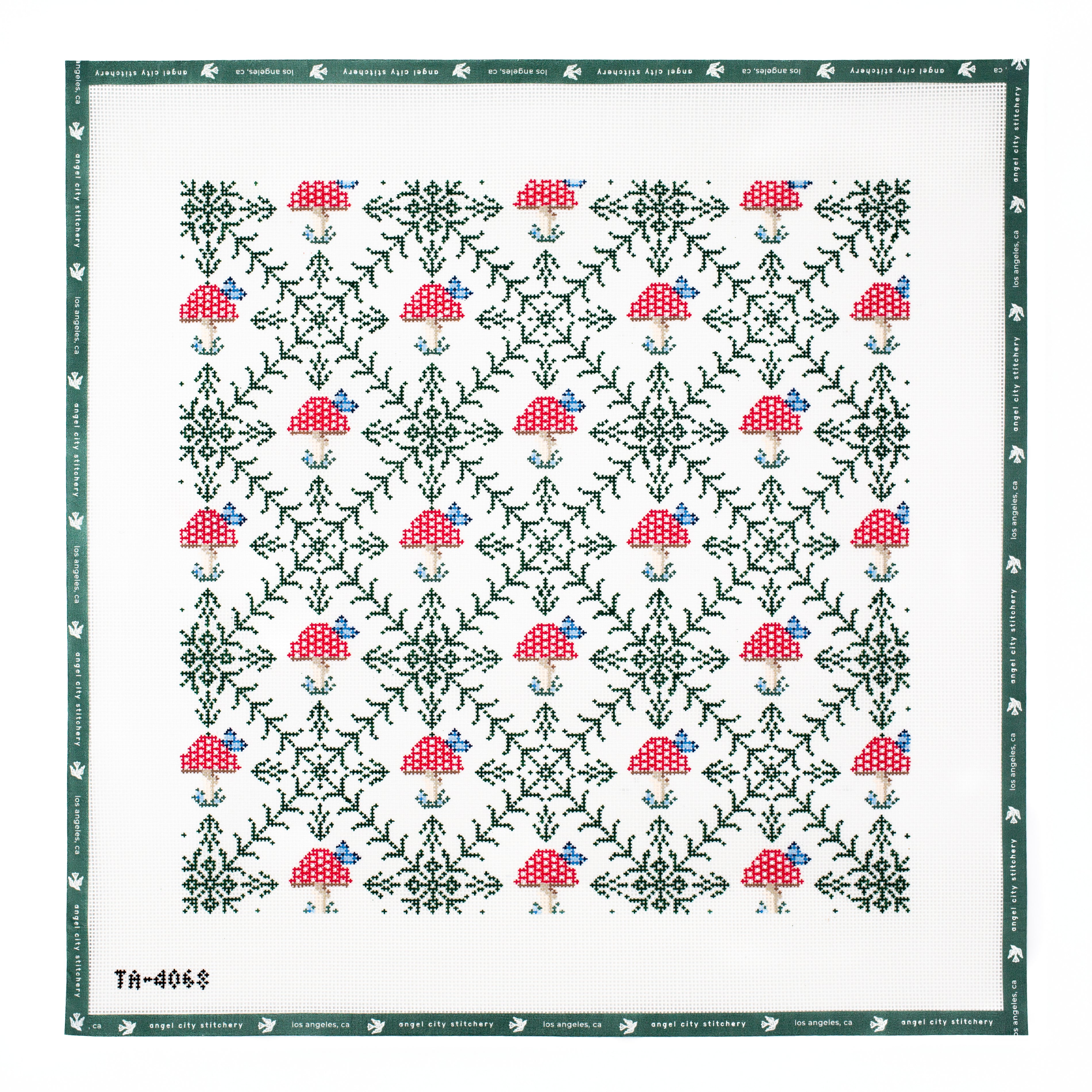 Embroidery canvas Patterned fabric with red and green mushrooms on a white background