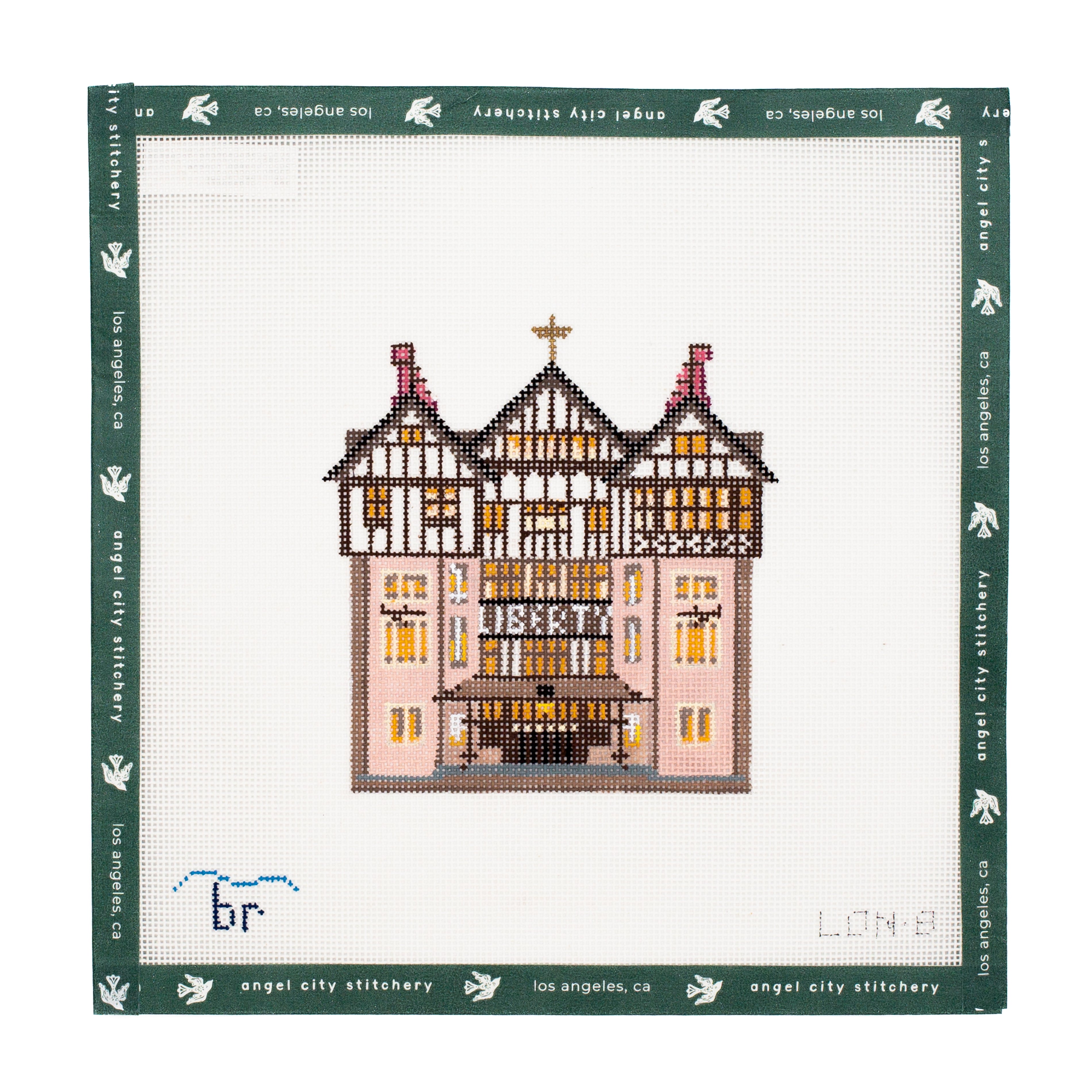 Embroidery canvas of a building on a white fabric with green border, featuring 'Angel City Stitchery' branding.