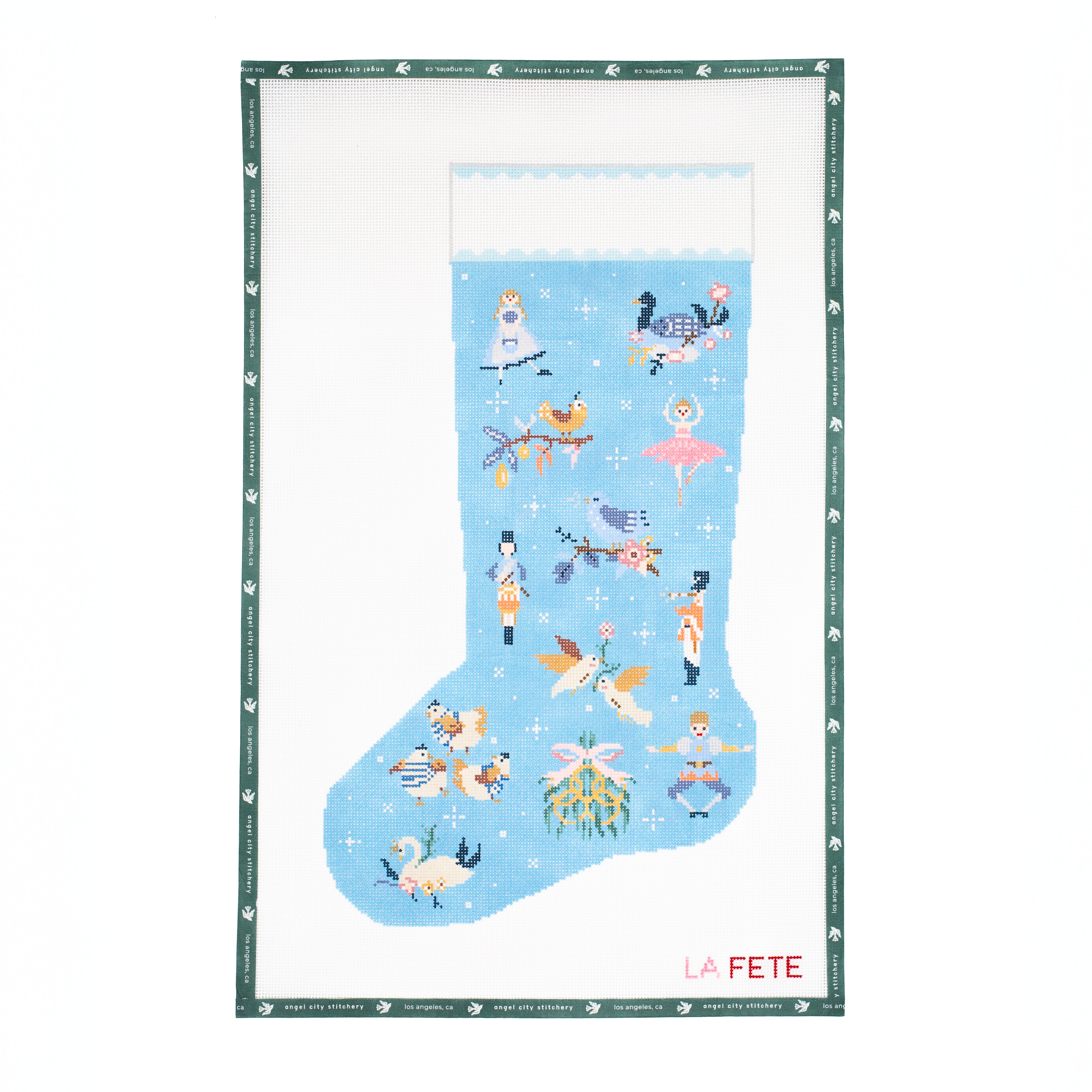 Needlepoint canvas of decorative stocking with fairy tale characters on a blue background, featuring the brand 'La Fete'.