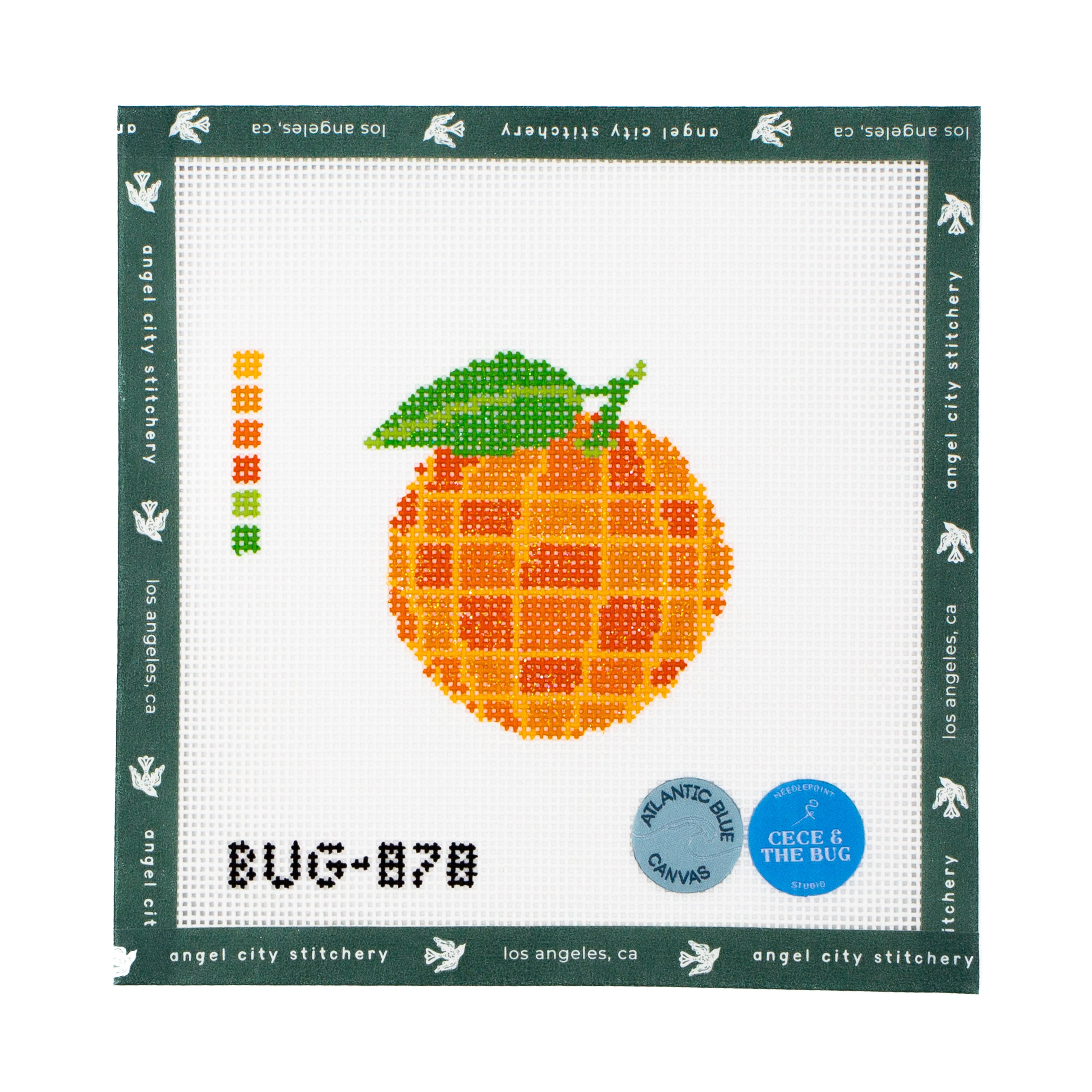 Needlepoint pattern of an orange with a green leaf on a white background, featuring branding text.