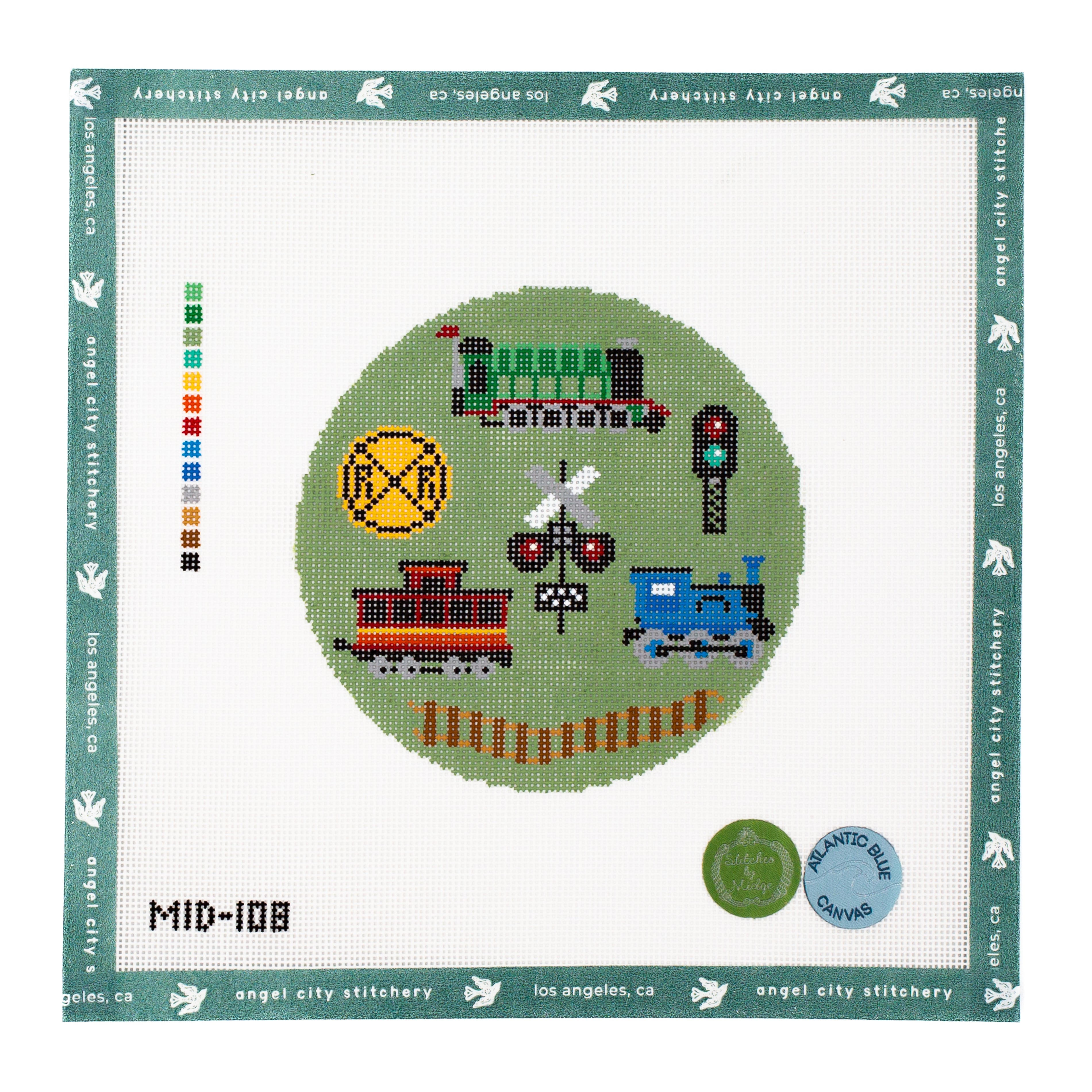 Railroad-themed circular needlepoint canvas featuring a green train, a blue train, a red caboose, a yellow railroad crossing sign, a crossing signal, a traffic light, and a set of tracks on a green background