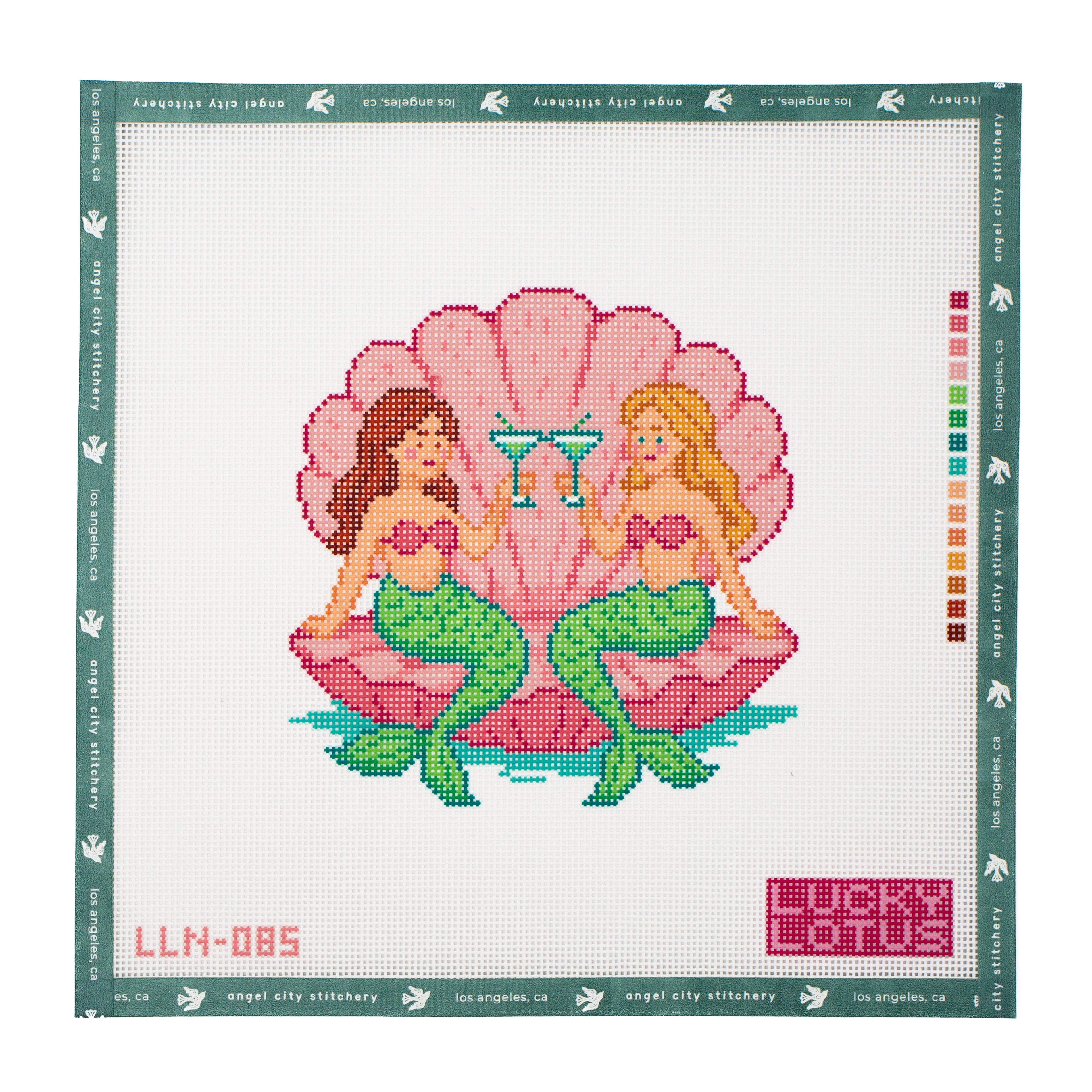 Two mermaids with green tails sitting inside a pink scallop shell and toasting with cocktails needlepoint canvas by Angel City Stitchery