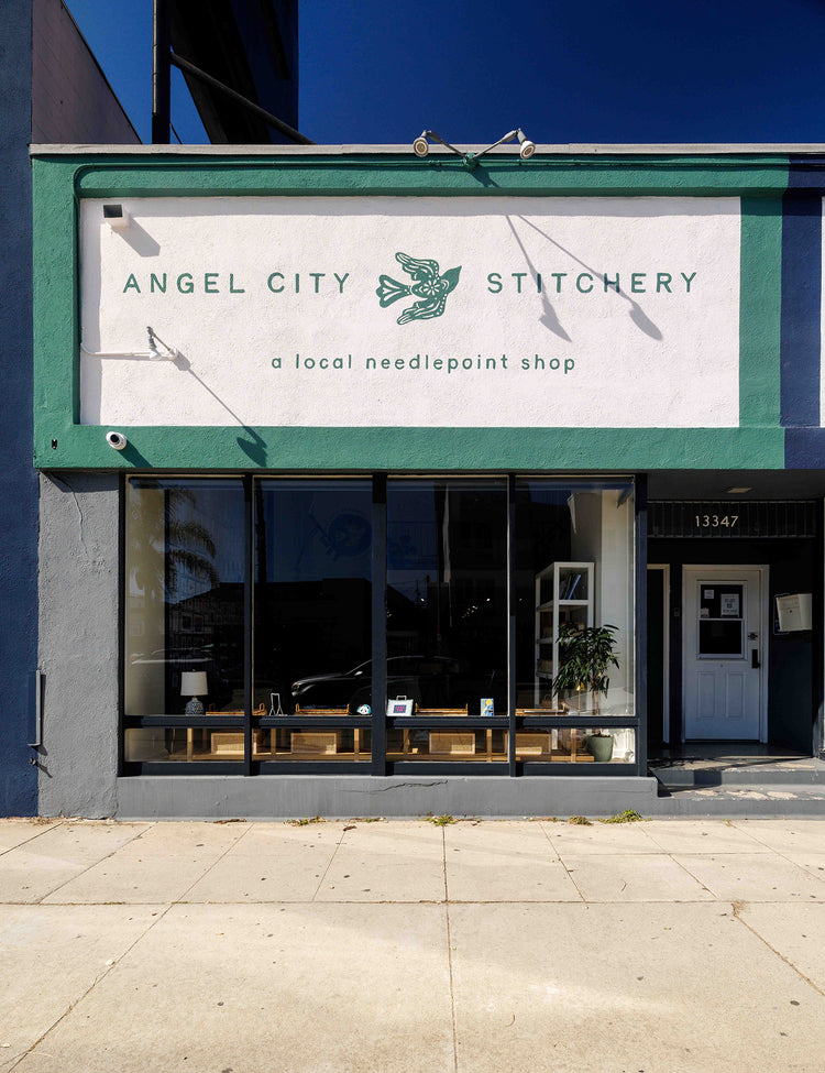  storefront of Angel City Stitchery with a sign above the entrance