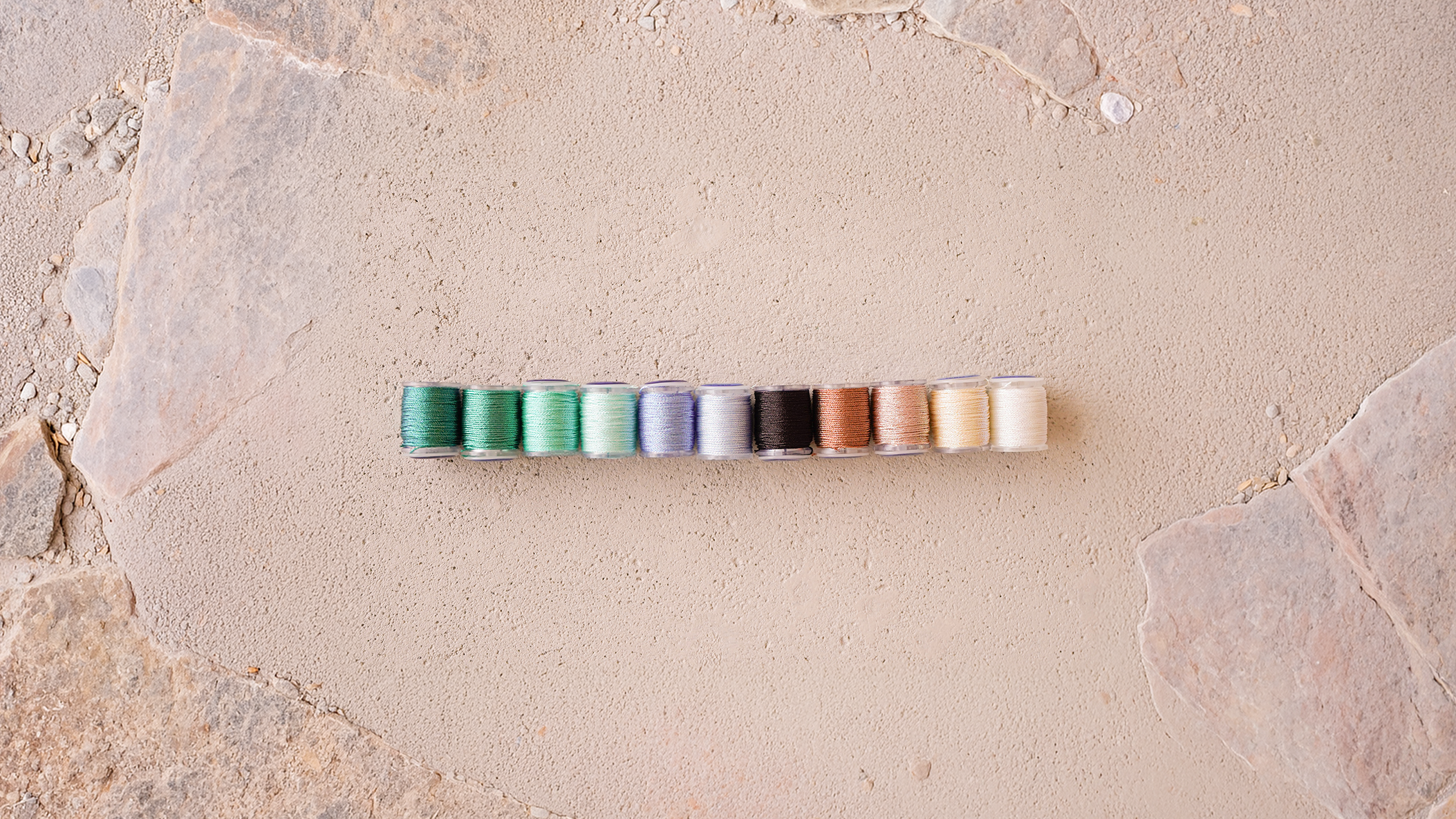 Row of colorful cylindrical objects on a textured stone surface